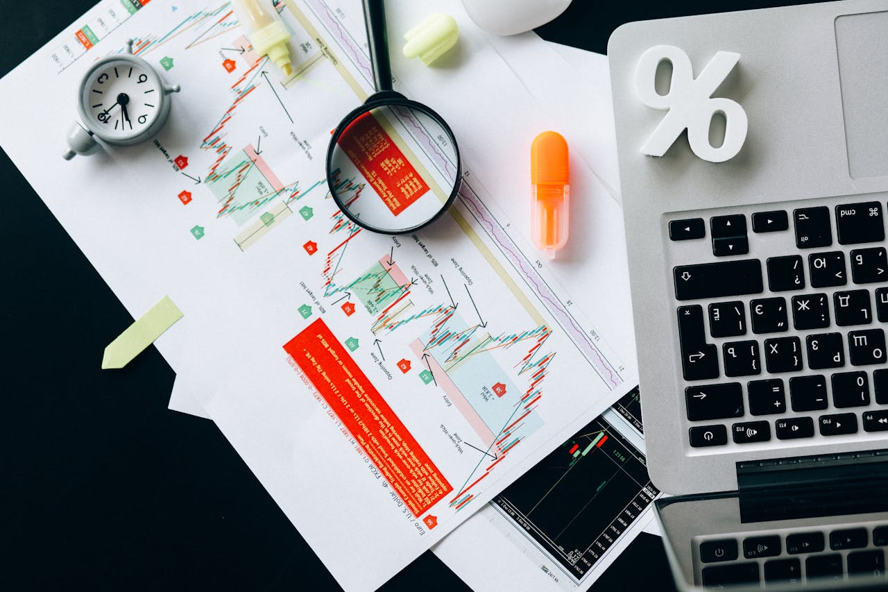 heros-img Top view of financial documents, charts, and laptop organized on a desk.